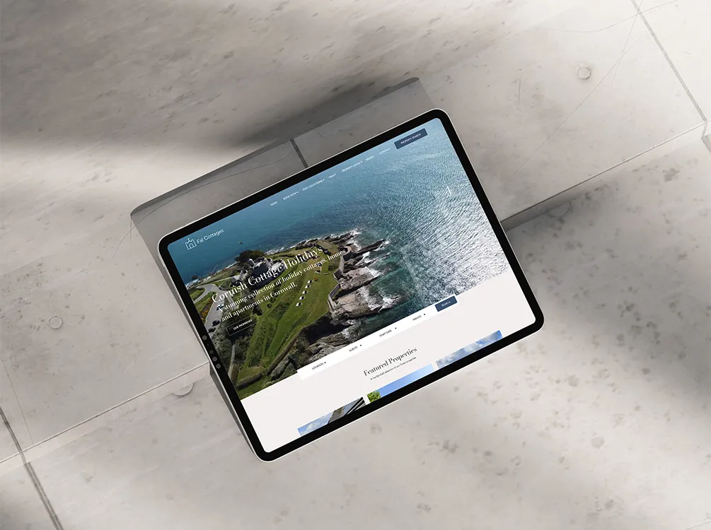 An iPad showing the Fal Cottages website homepage