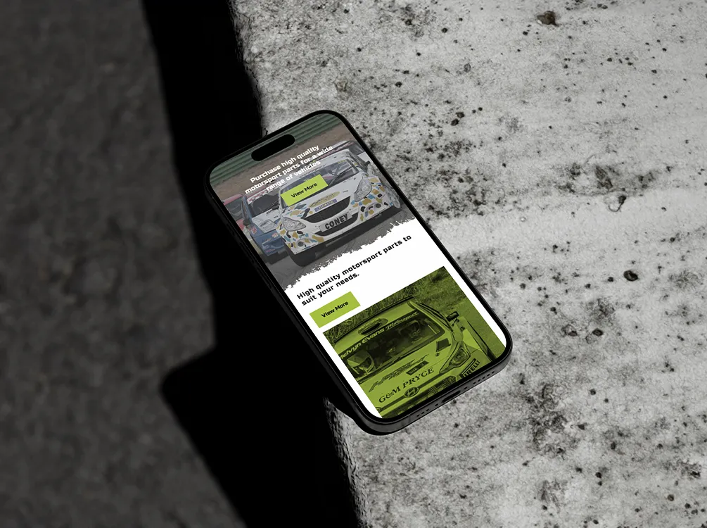 An iPhone on a concrete surface showing the Harry Hockly website homepage