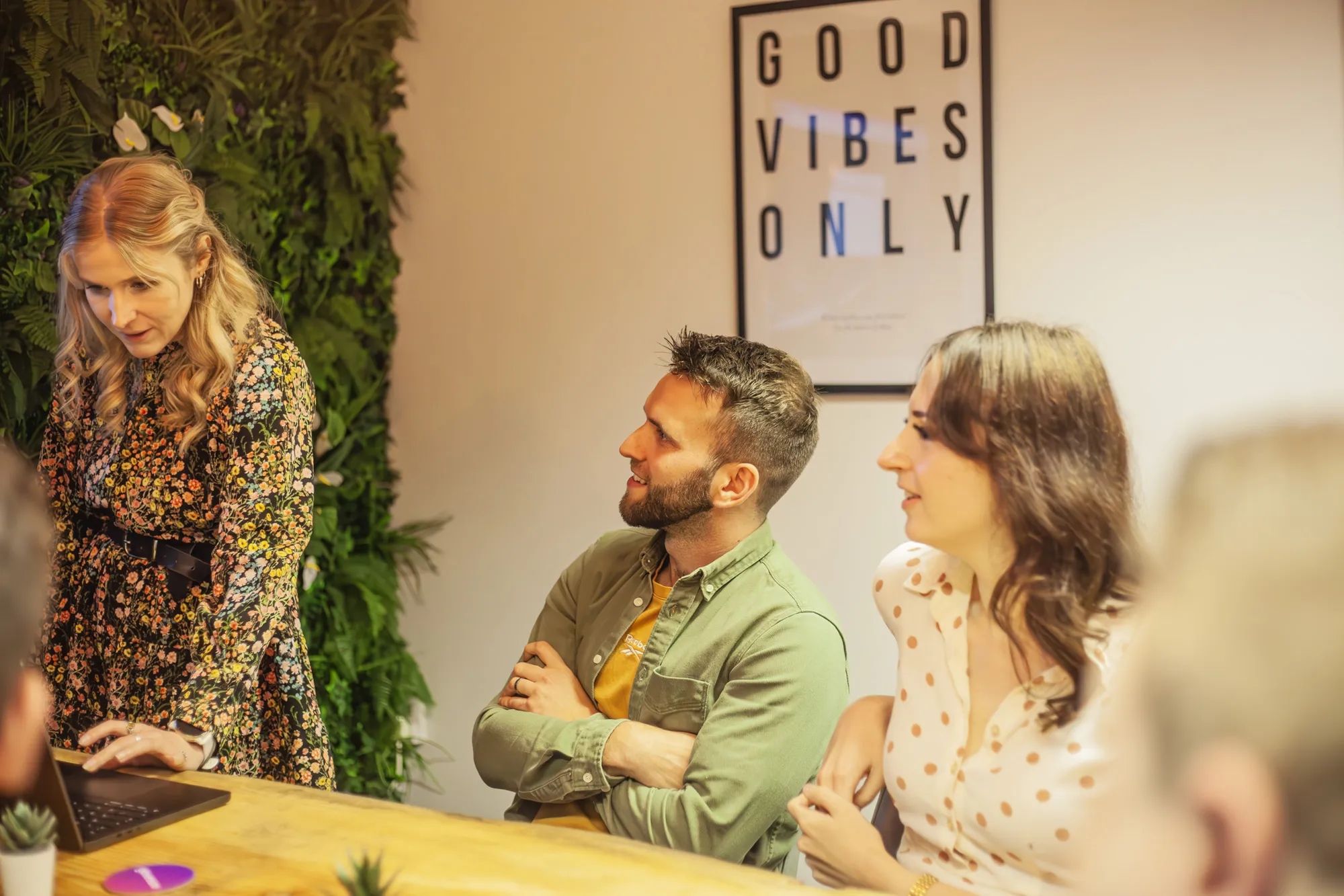 People sat around a wooden table talking and smiling
