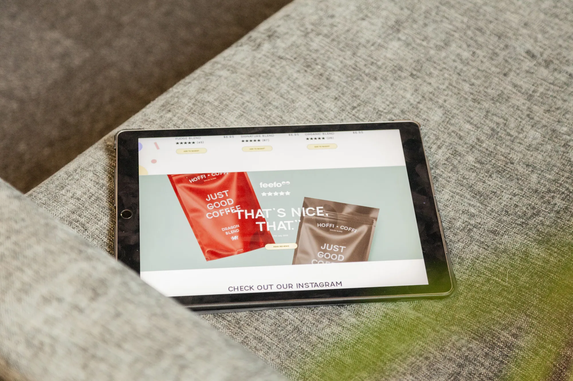 An iPad on a grey sofa showing an eCommerce website for a coffee company