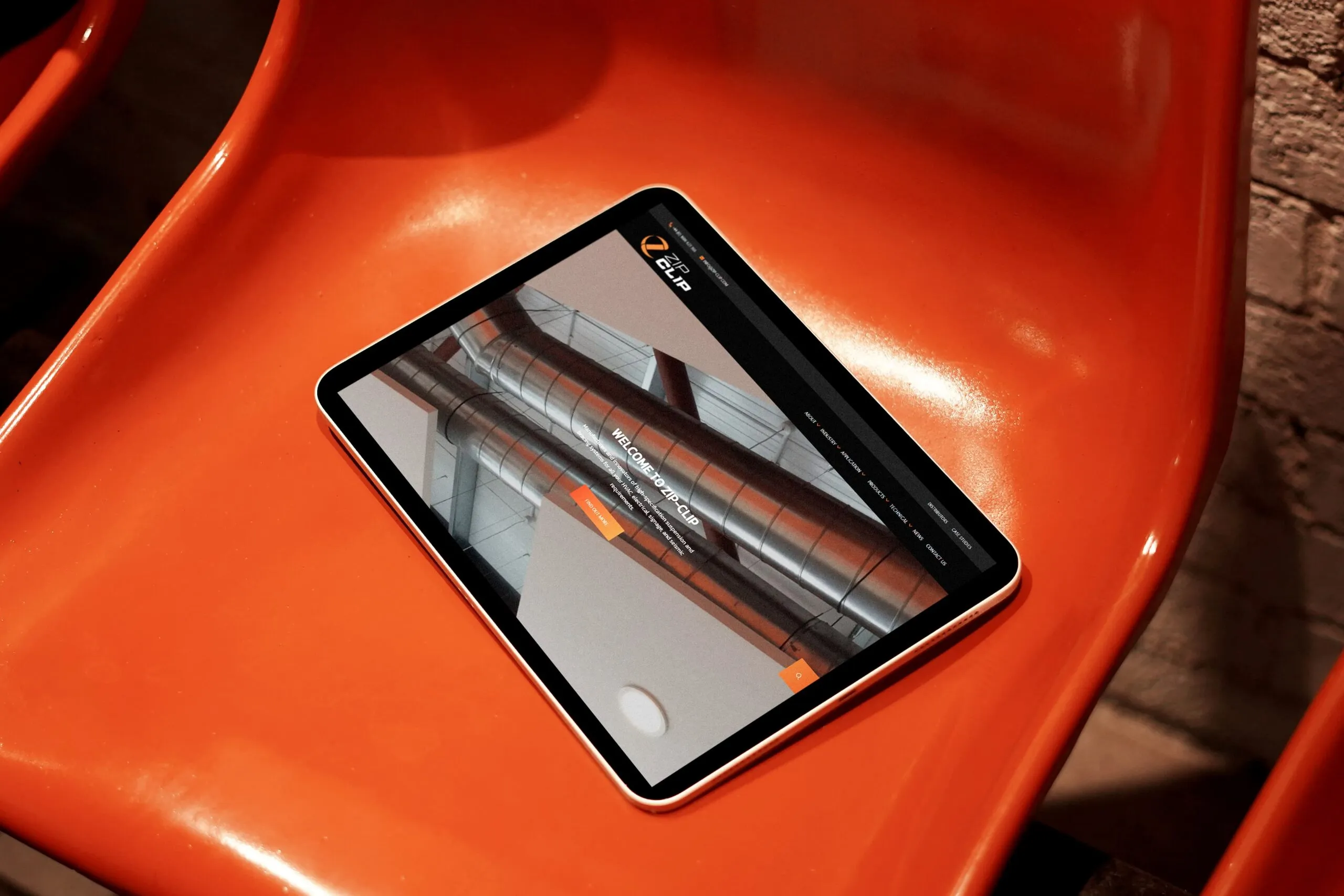 An iPad on a plastic outdoor chair showing  the ZipClip website homepage