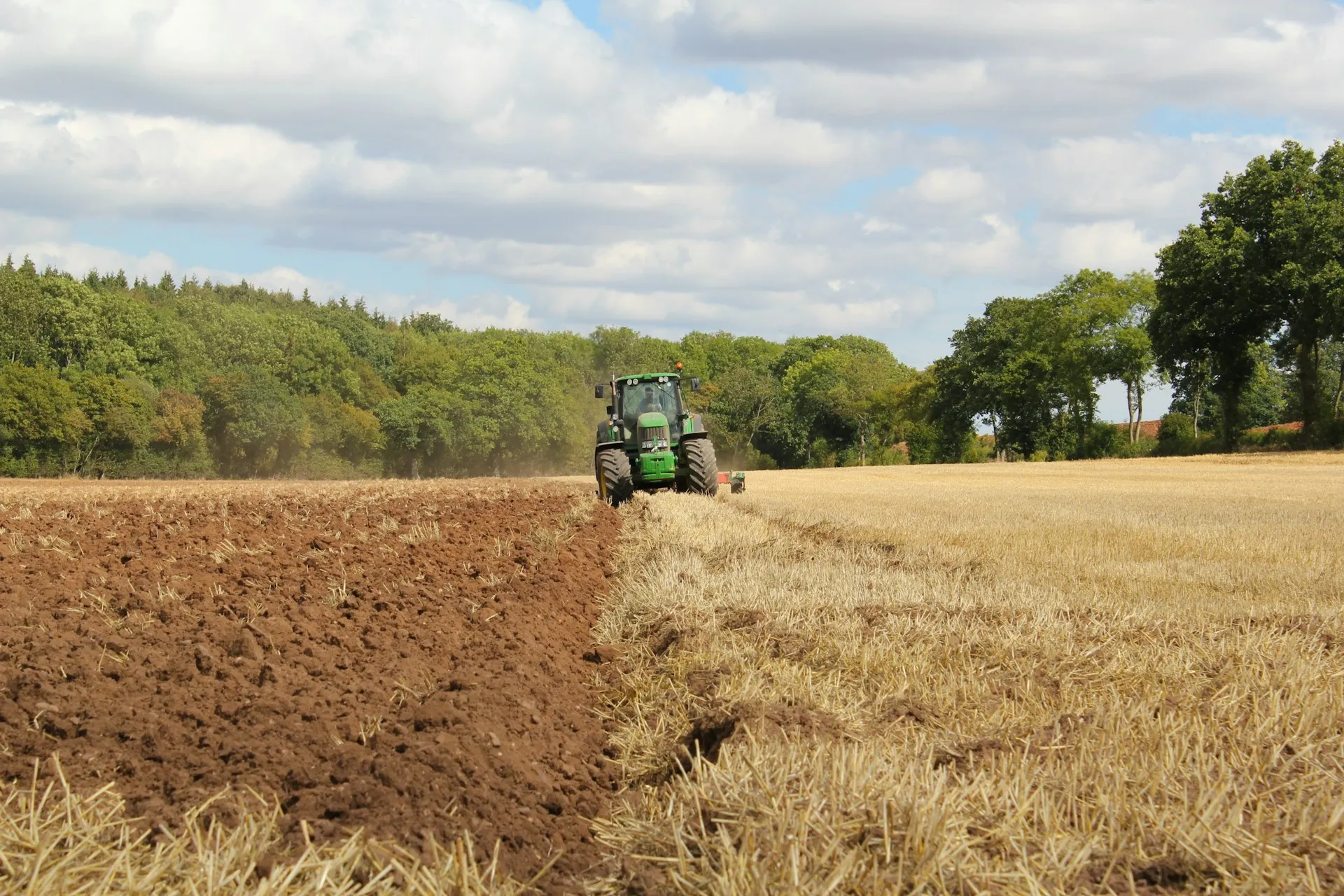 A tractor ploughing a field on a sunny day