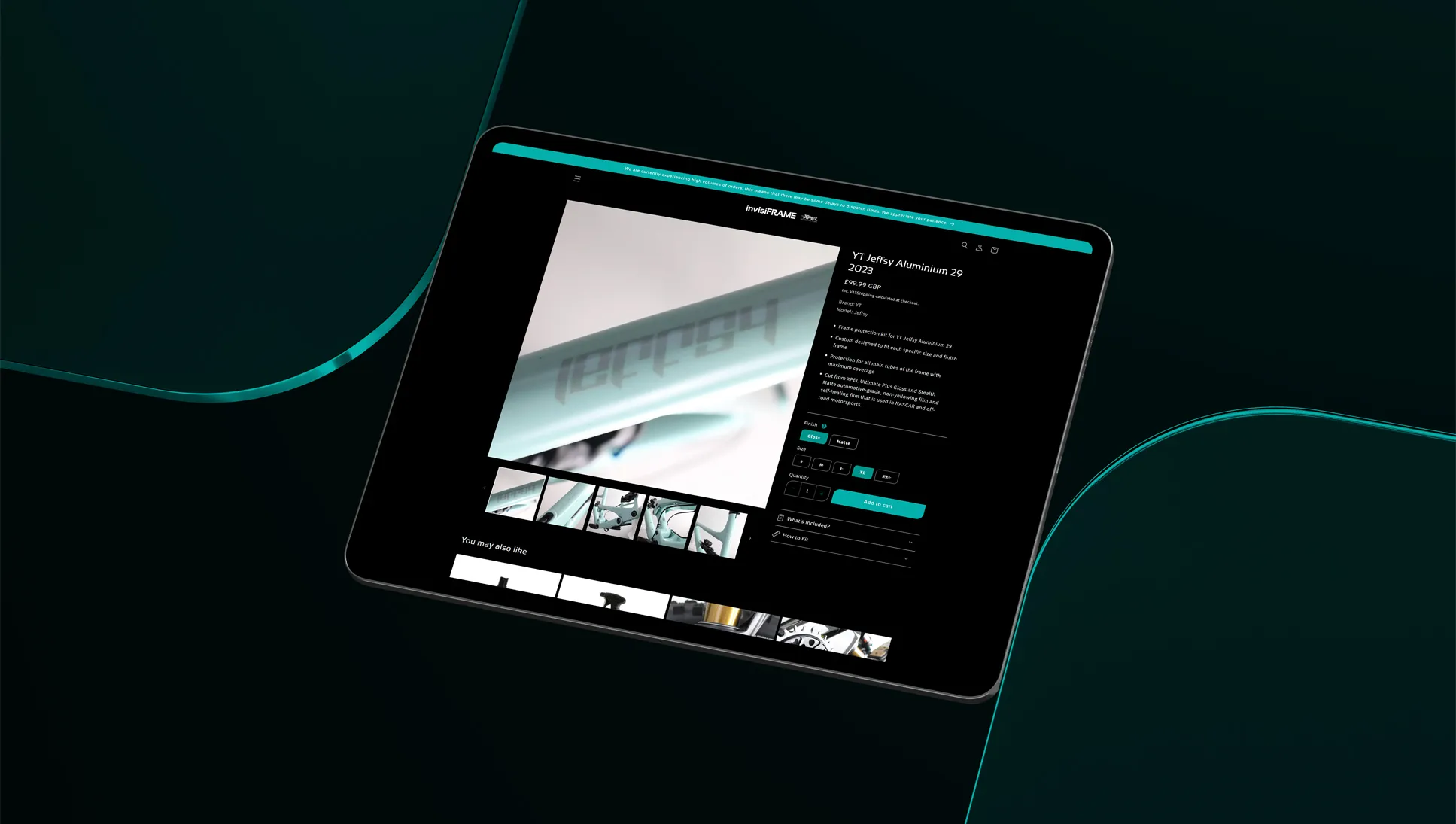 An iPad balancing between two transparent teal sections showing the Invisiframe product page