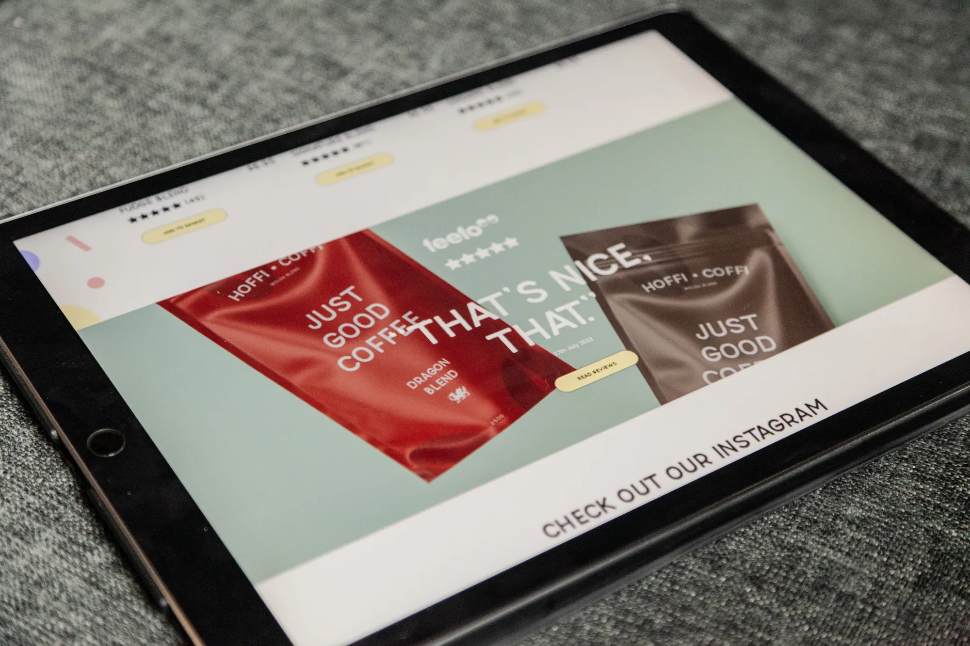 An iPad on a grey sofa showing a testimonials section for a coffee company website