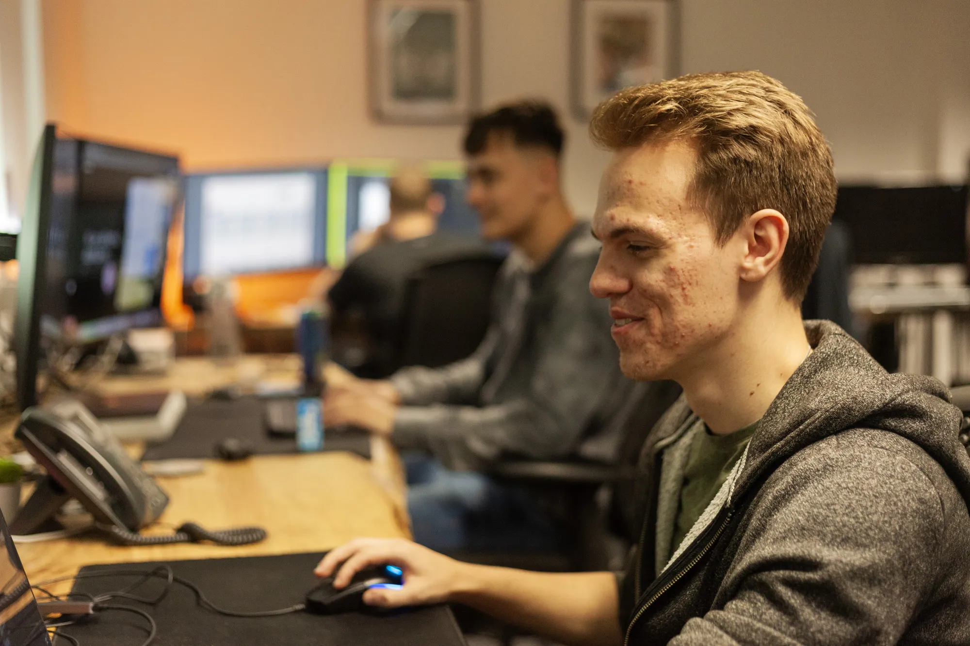 A man sat at a desk looking at a computer