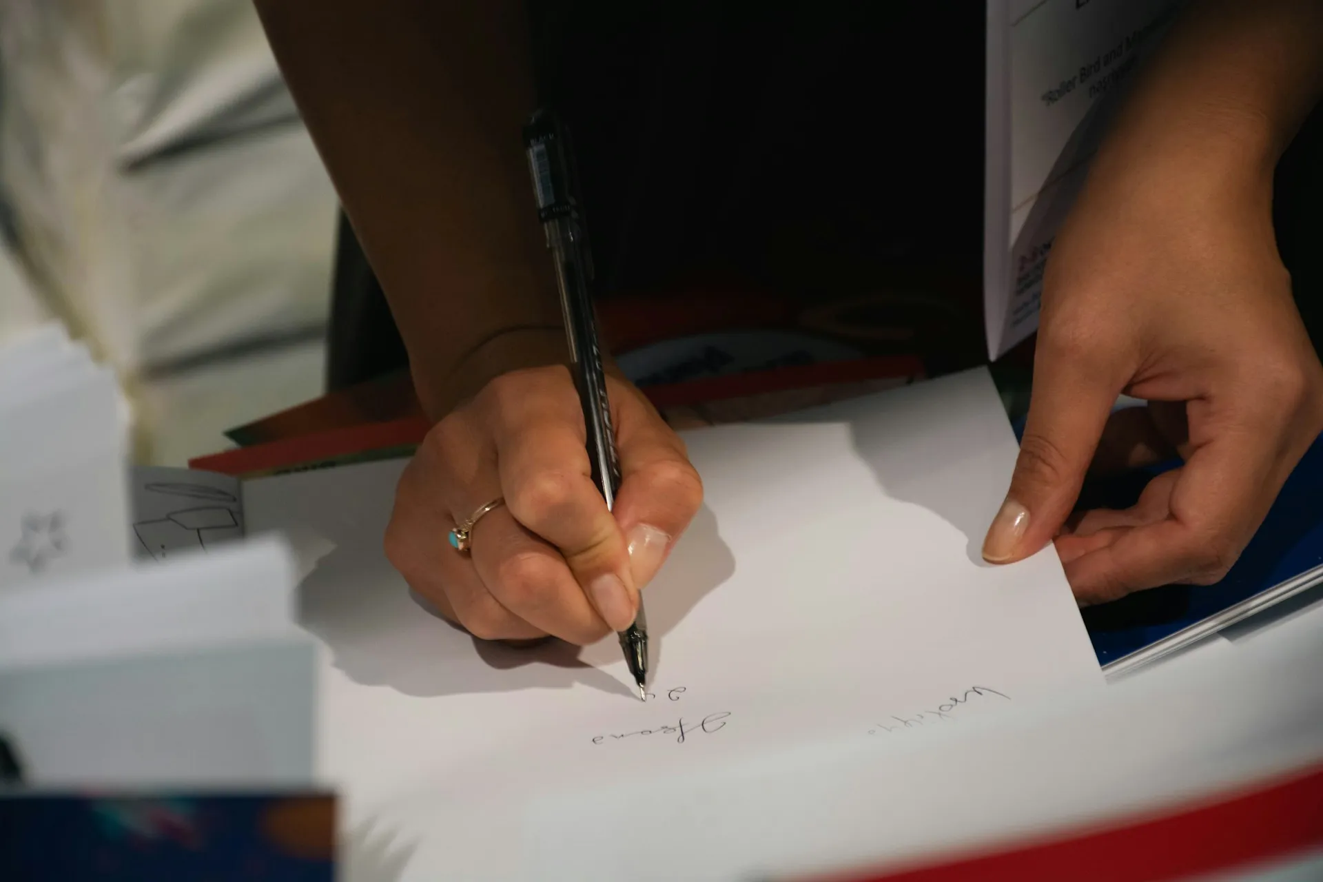 A person writing on a sheet of paper