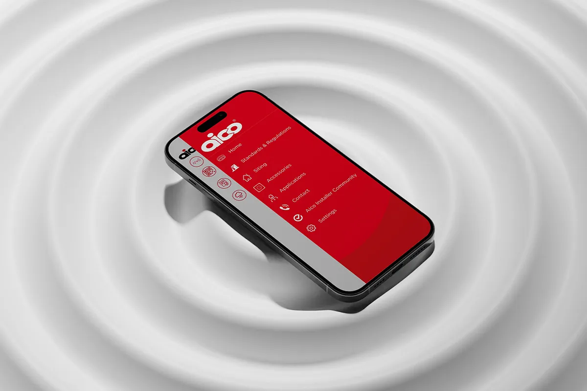 An iPhone on a white rippling surface showing the Aico Handybook App onscreen