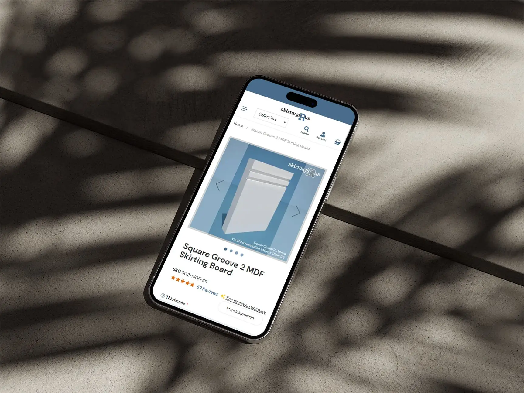 An iPhone on a concrete surface showing the Skirtings R Us website product page