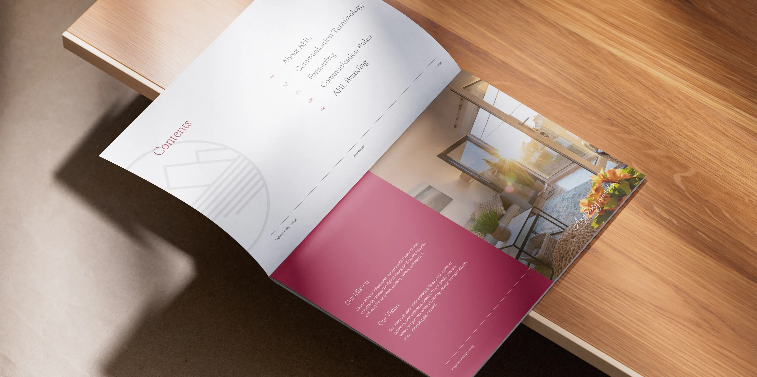 A brochure on a wooden table showing the Anglesey Holiday Lettings brand refresh