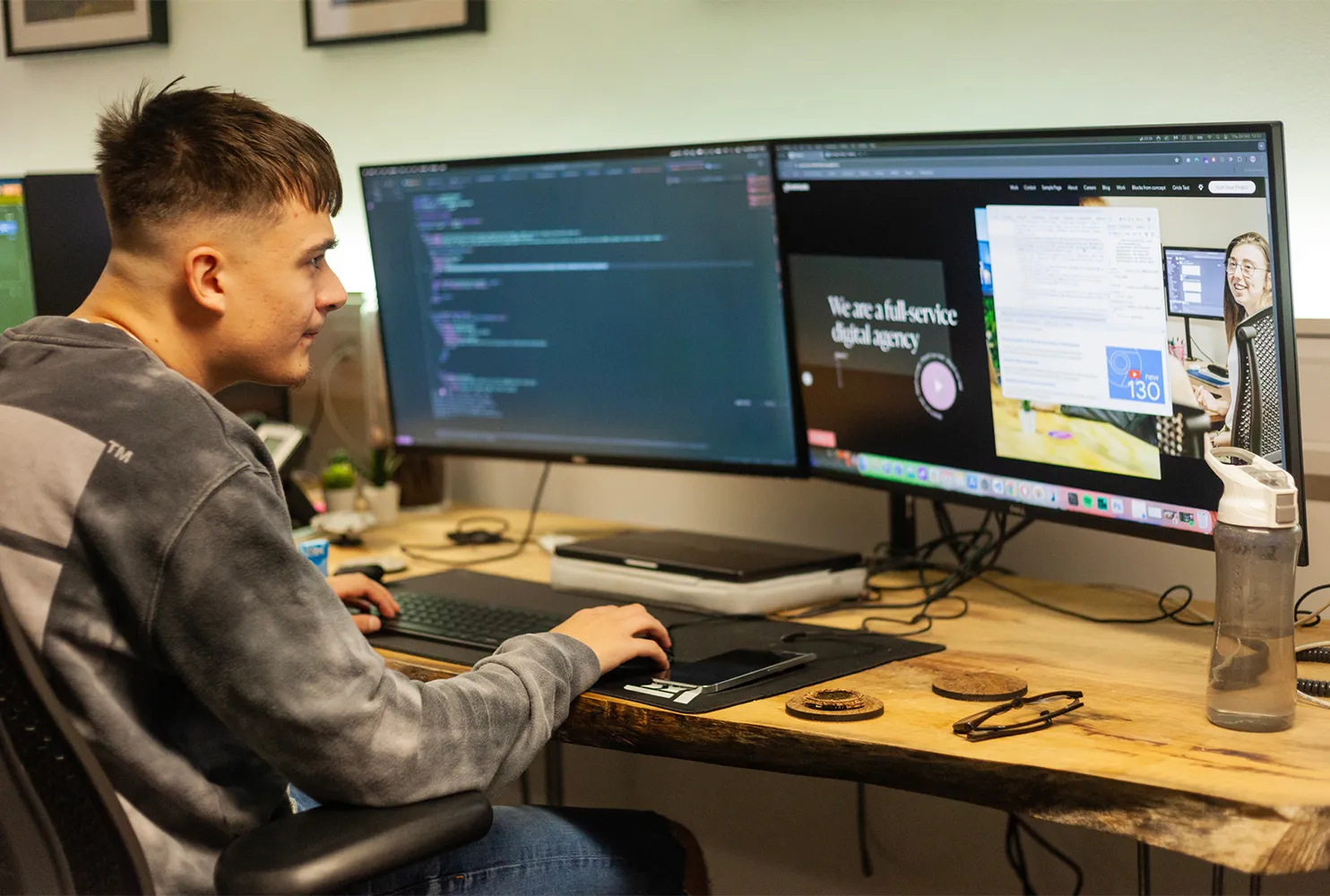 A man sitting at a desk looking at a computer screen showing the new gloversure website