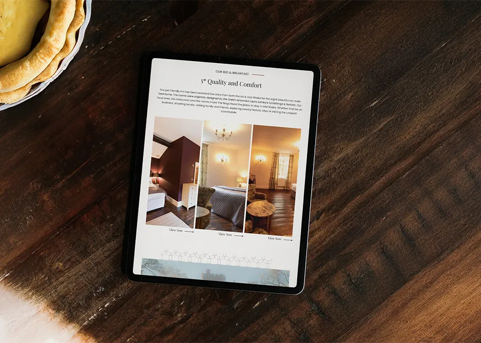 A tablet displaying the Nags Head website on a dark wooden table