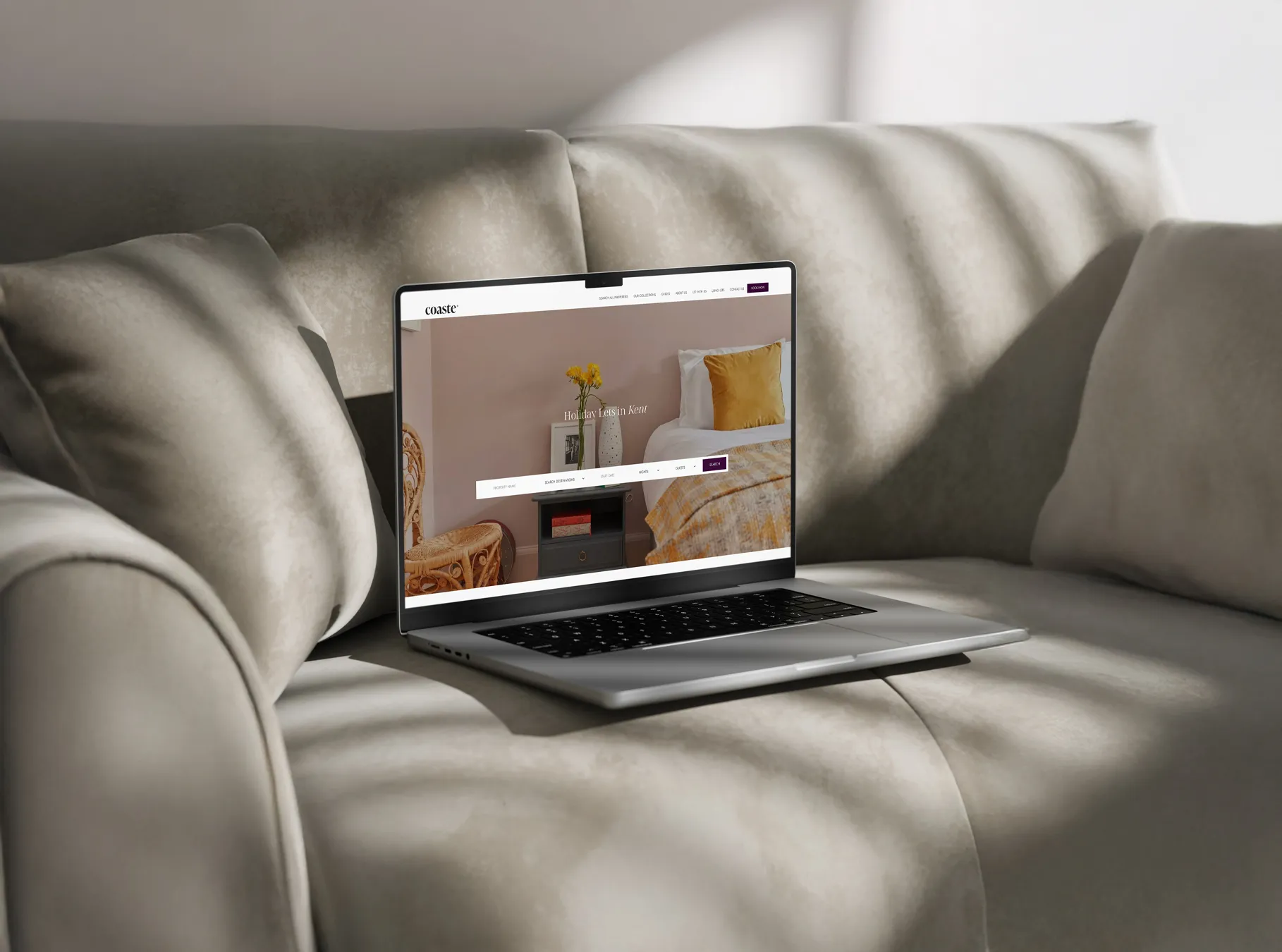 Laptop on a beige sofa displaying a the Coaste website