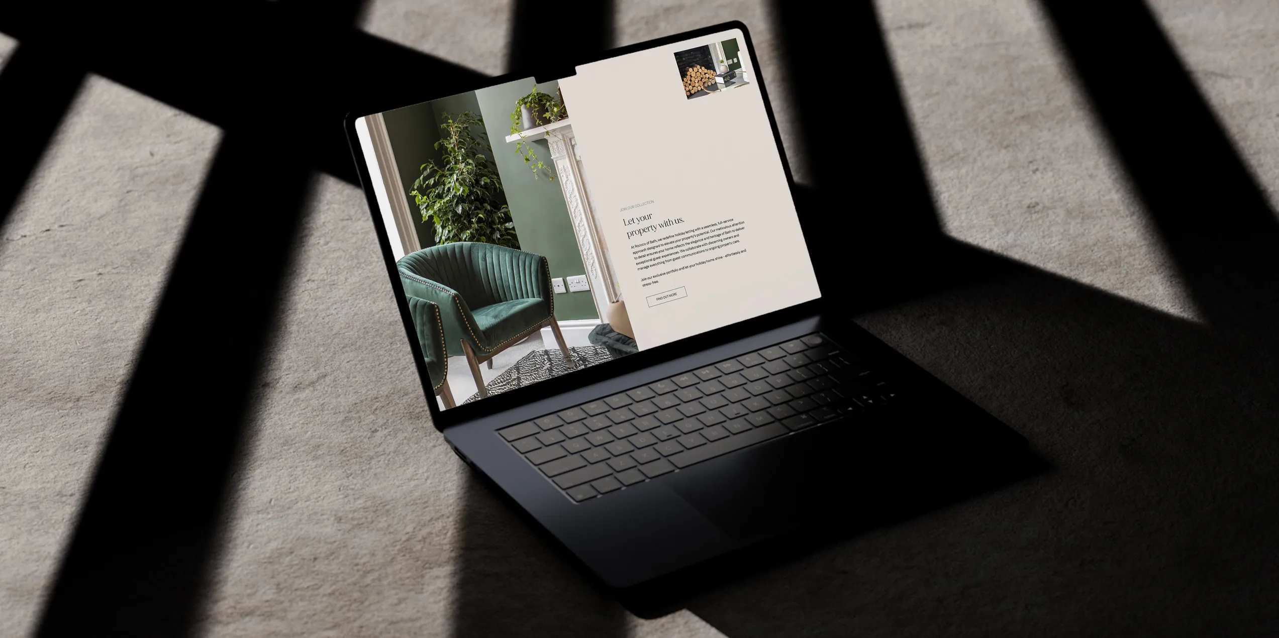 A MacBook on a concrete surface showing property imagery