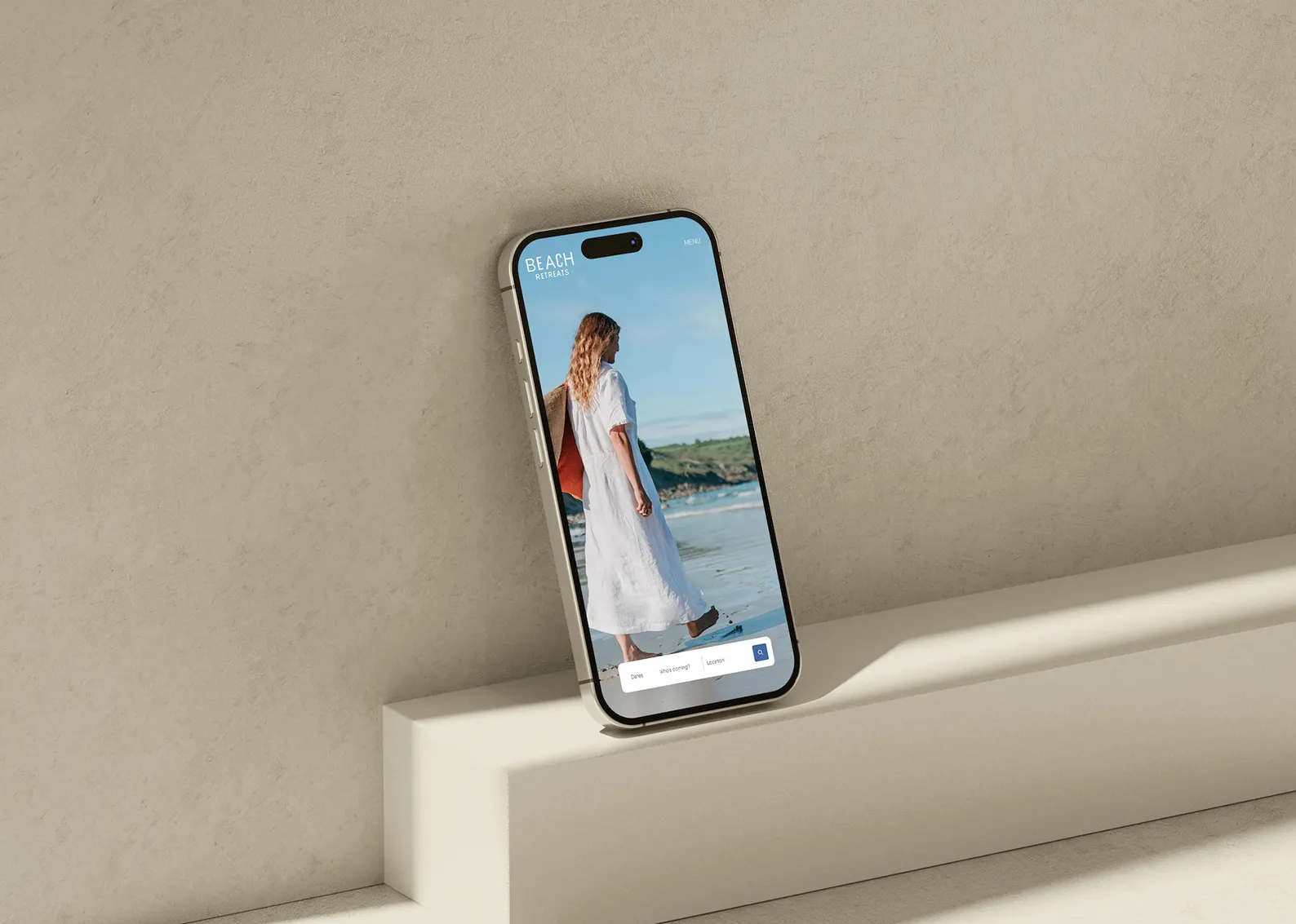 An iPhone leaning on a concrete wall showing the Beach Retreats homepage